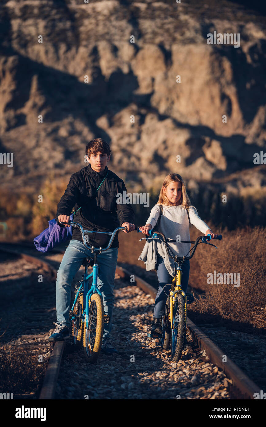 Garçon et fille sur la voie avec les vélos Banque D'Images