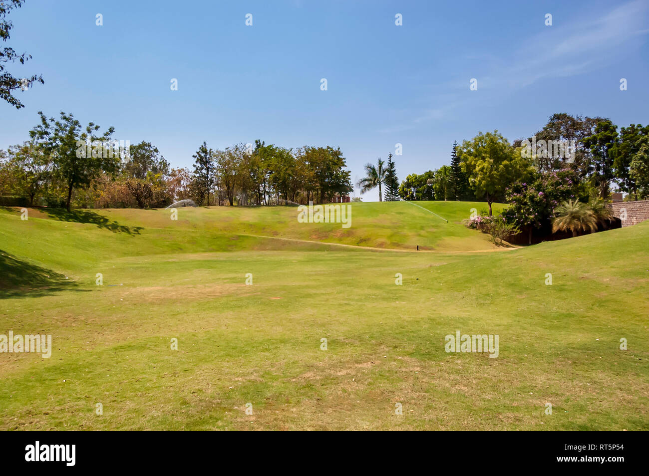 Aspersion d'eau pulvériser de l'eau sur une pelouse verte, baignade sous le soleil de l'après-midi, à la The Golkonda Resorts and Spa à Hyderabad, Inde, Telangana. Banque D'Images