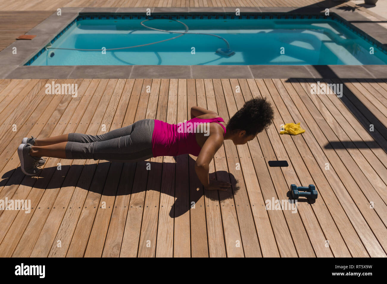 Woman performing push-up de l'exercice dans l'arrière-cour d'accueil Banque D'Images