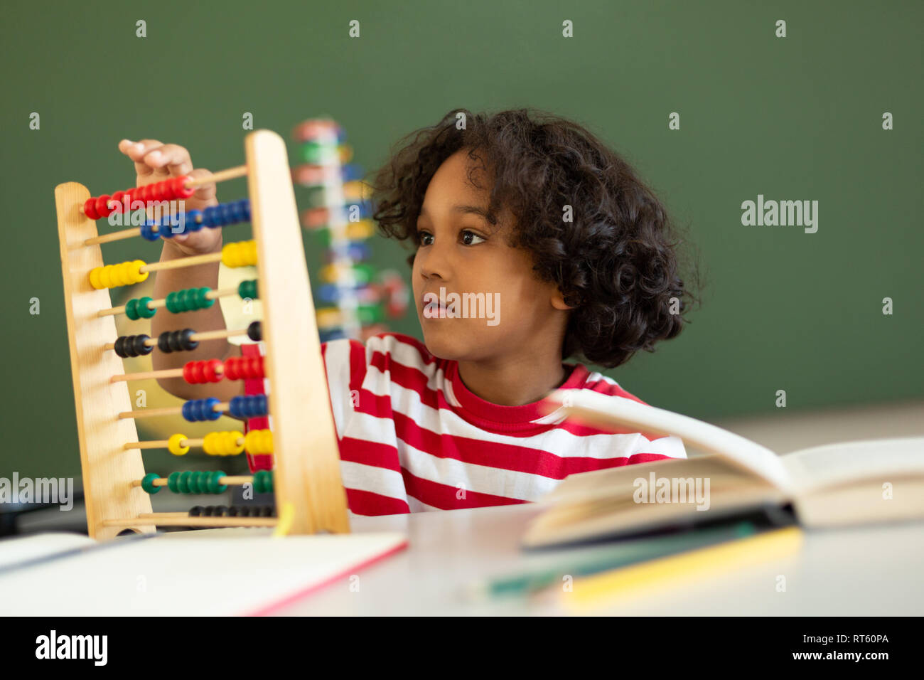 Garçon l'apprentissage des mathématiques avec abacus dans une salle de classe Banque D'Images