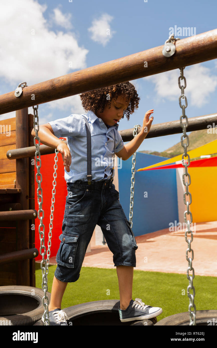 Balades d'écolière sur la pendaison des pneus dans la cour de l'école Banque D'Images