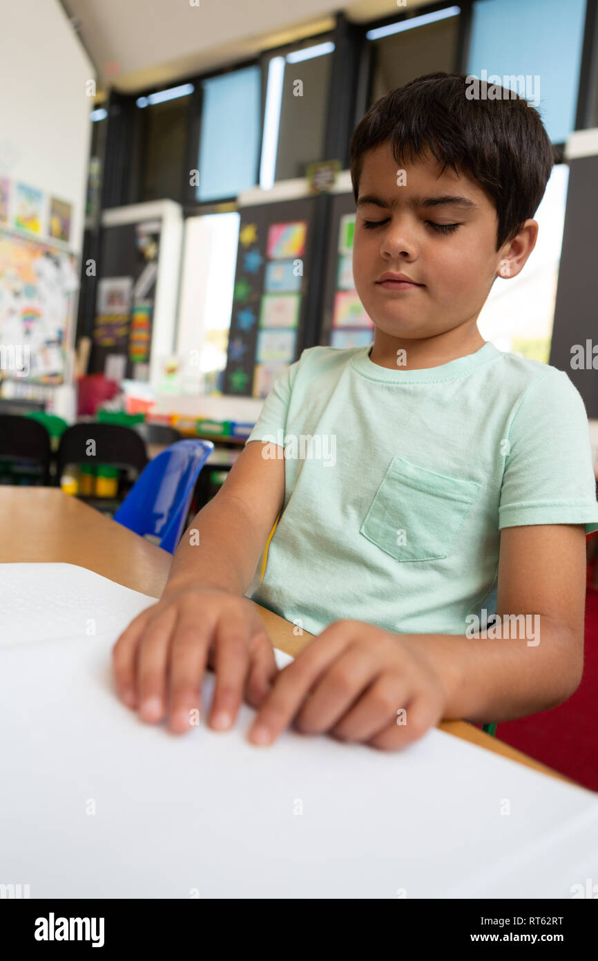 Écolier aveugle de lire un livre en braille en classe Banque D'Images