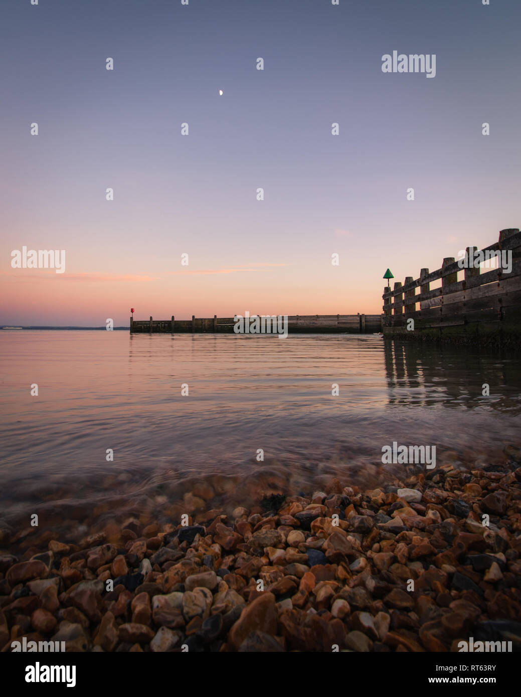Coucher du soleil sur la plage avec des eaux tranquilles Banque D'Images