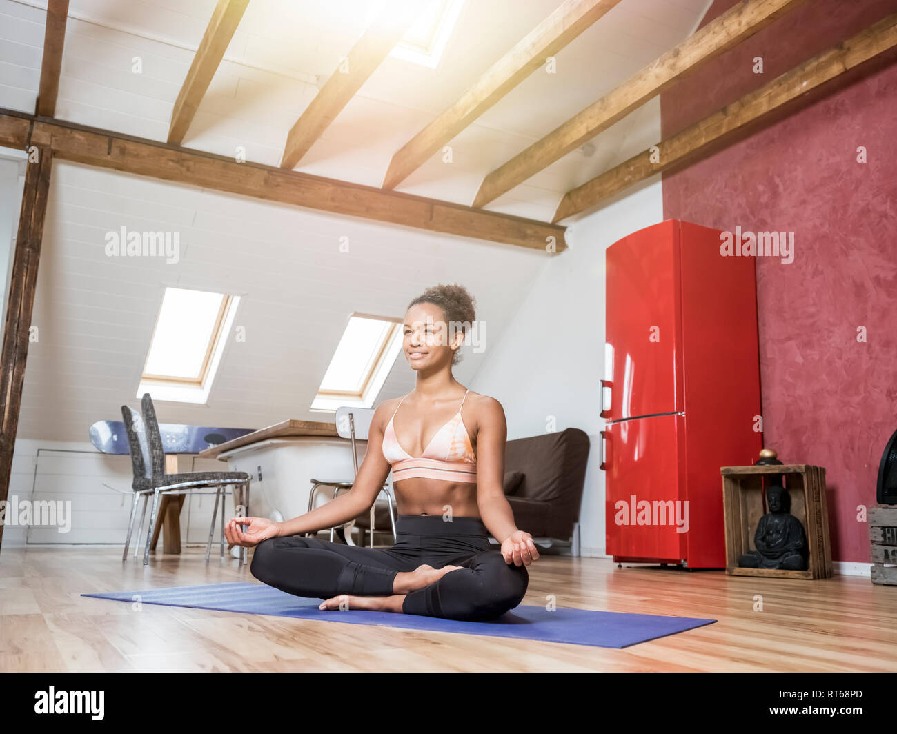 Smiling young woman practicing yoga Banque D'Images