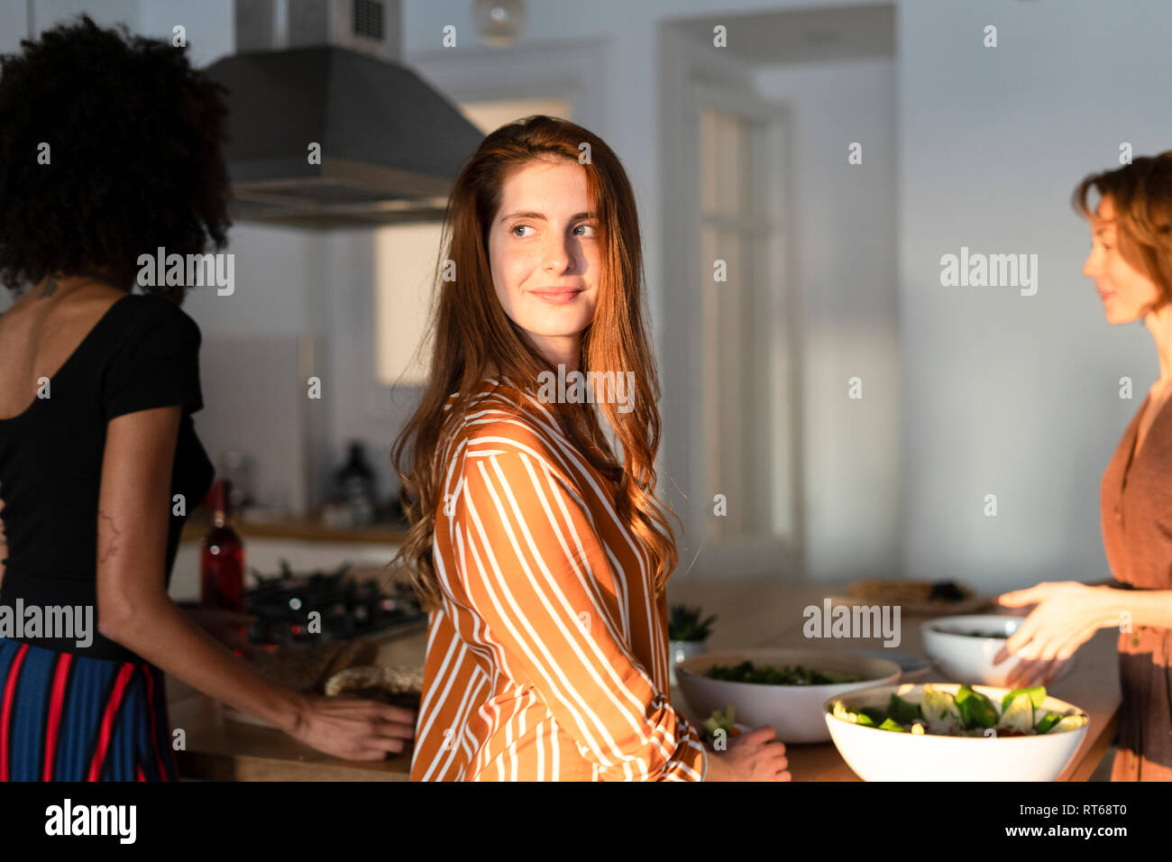 Friends standing dans la cuisine, la préparation d'un dîner Banque D'Images