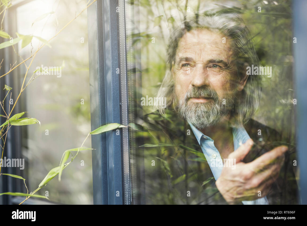 Senior businessman standing par fenêtre, using smartphone Banque D'Images Senior businessman standing par fenêtre, using smartphone Banque D'Images