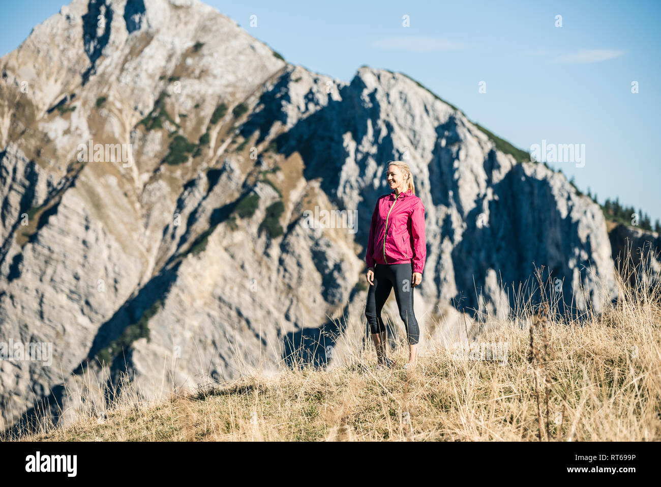 Autriche, Tyrol, smiling female athlete standing on pré alpin Banque D'Images