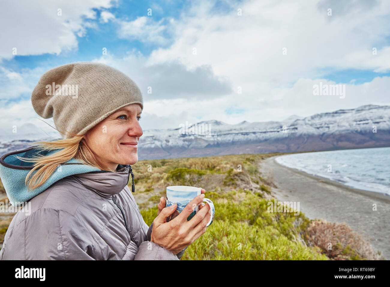 L'Argentine, Lago Posadas, woman holding mug at lakeside Banque D'Images