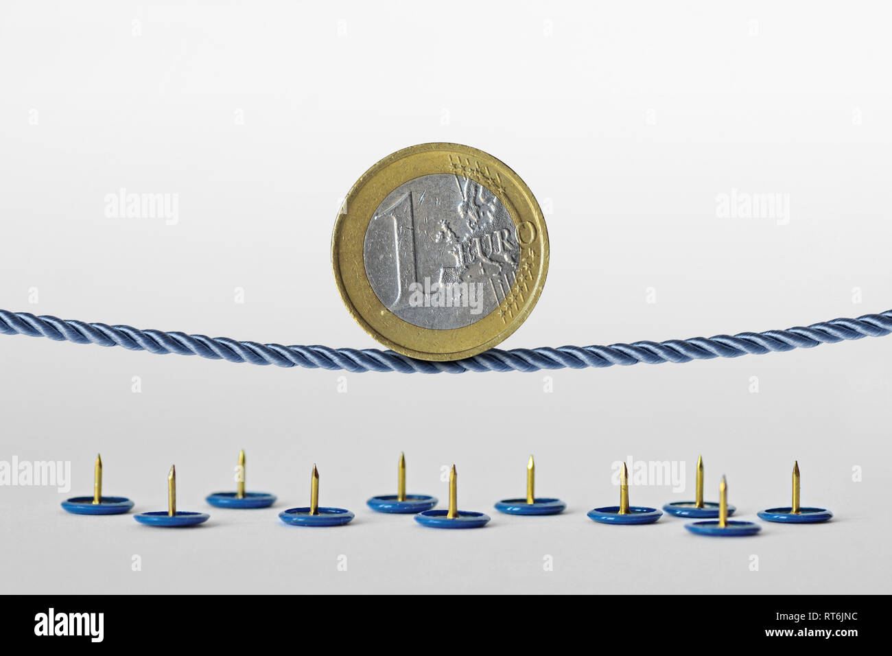 Pièce en euro en équilibre sur corde sur des punaises - Notion de risque de change de l'euro Banque D'Images