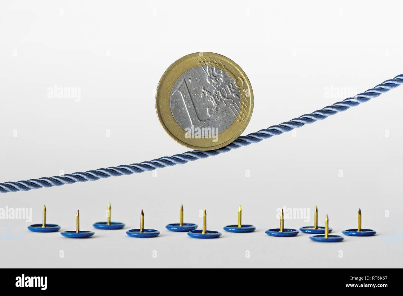 Pièce en euros sur corde sur des punaises - Concept de tendance à la hausse de l'euro et le risque de change euro Banque D'Images
