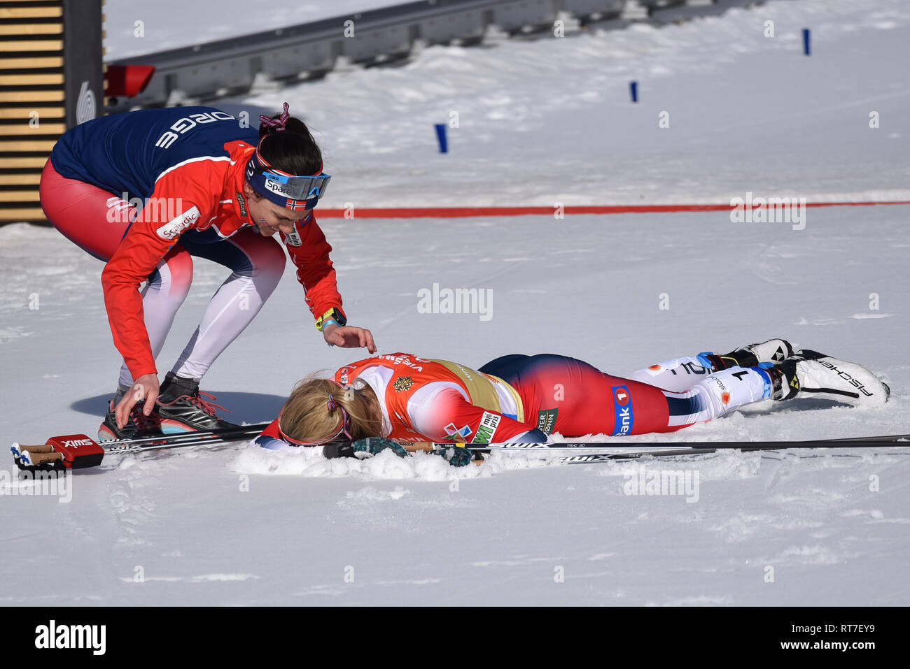 Seefeld, Autriche, 28 février 2019. Quelle était sa température ? Si chaud que le skieur numéro 1 de l'équipe de ski norvégienne, Therese Johaug, a immédiatement plongé dans la neige après avoir terminé la jambe d'ancrage du relais féminin aux championnats du monde nordique. Les températures étaient dans les années 50 F. la Norvège a terminé deuxième. Heidi Weng, coéquipier, approche de Johaug. © John Lazenby/Alay Live News. Banque D'Images