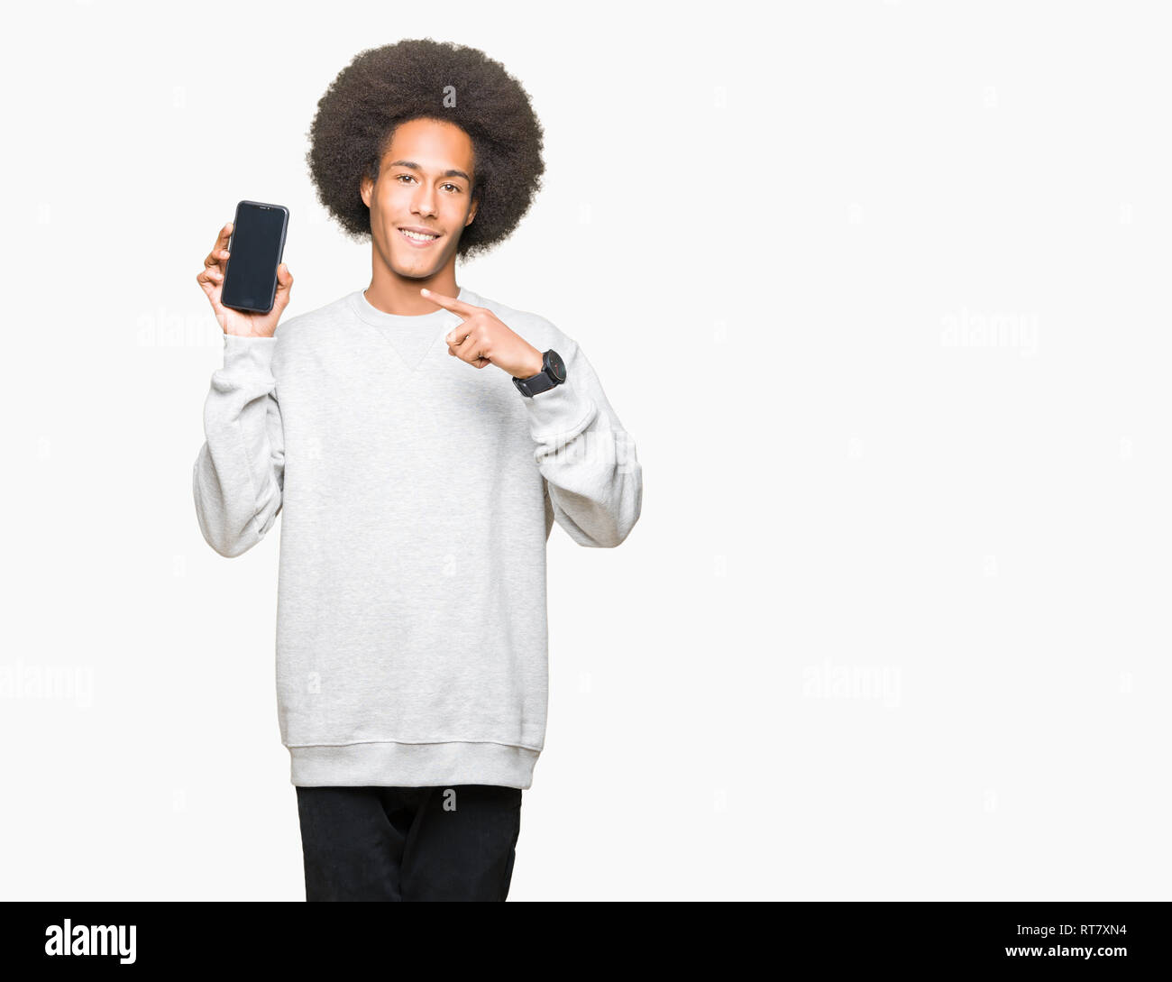 Young african american man with afro hair montrant l'écran du smartphone très heureux pointant avec la main et des doigts Banque D'Images