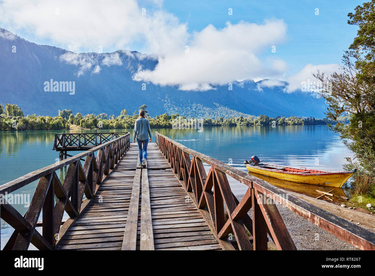 Chili, Lago Rosselot, Chaiten, woman walking on jetty Banque D'Images