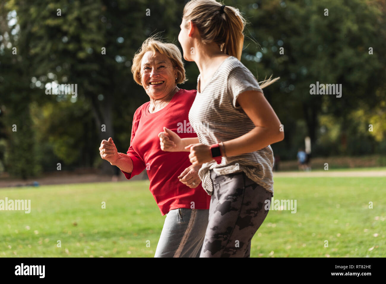 Petite-fille et grand-mère s'amuser, faire du jogging ensemble dans le parc Banque D'Images