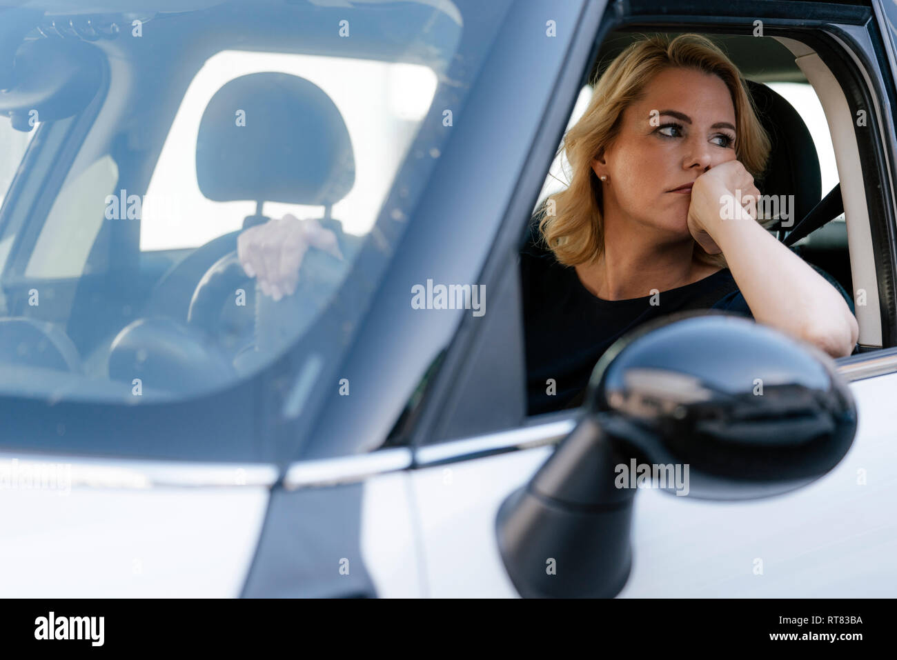 Bored woman looking out of car window Banque D'Images