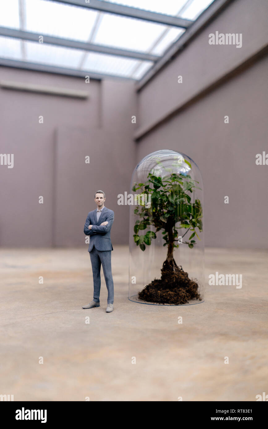 Figurine homme debout sous un arbre en pot de Bell Banque D'Images