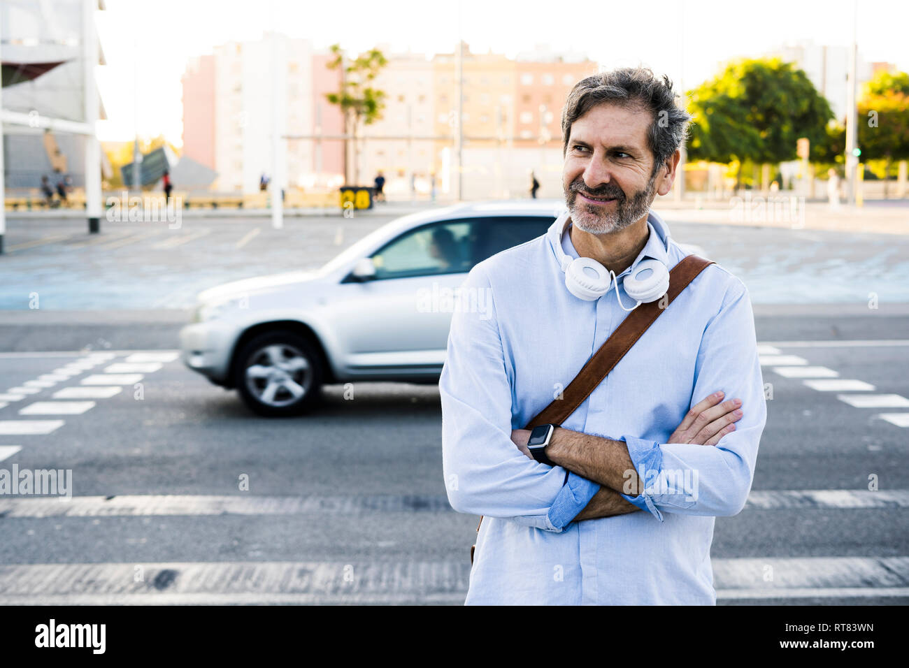 Portrait of smiling Young man with headphones debout à une rue Banque D'Images