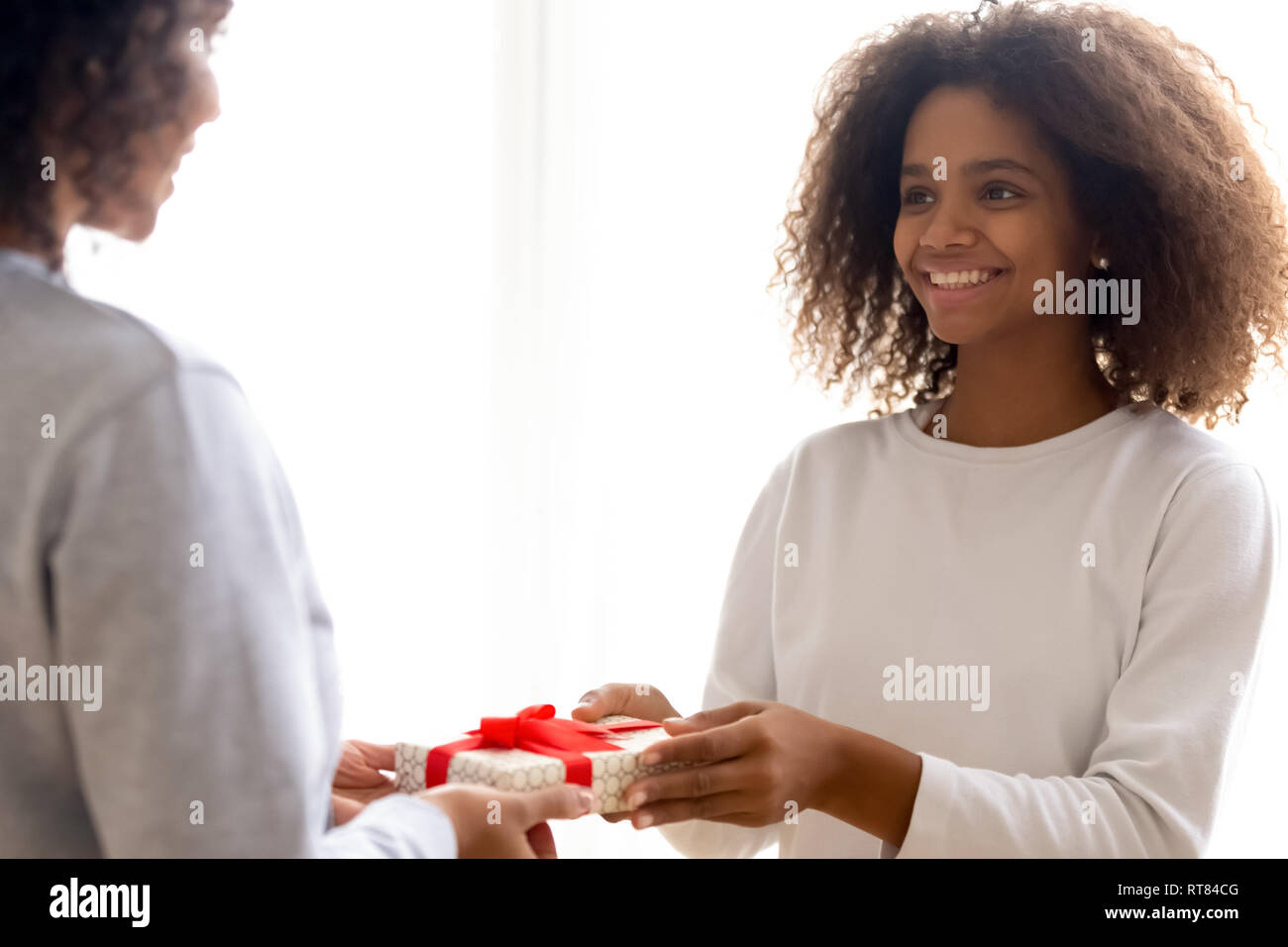 Happy mixed race fille donnant à présent Mère bien-aimée Banque D'Images