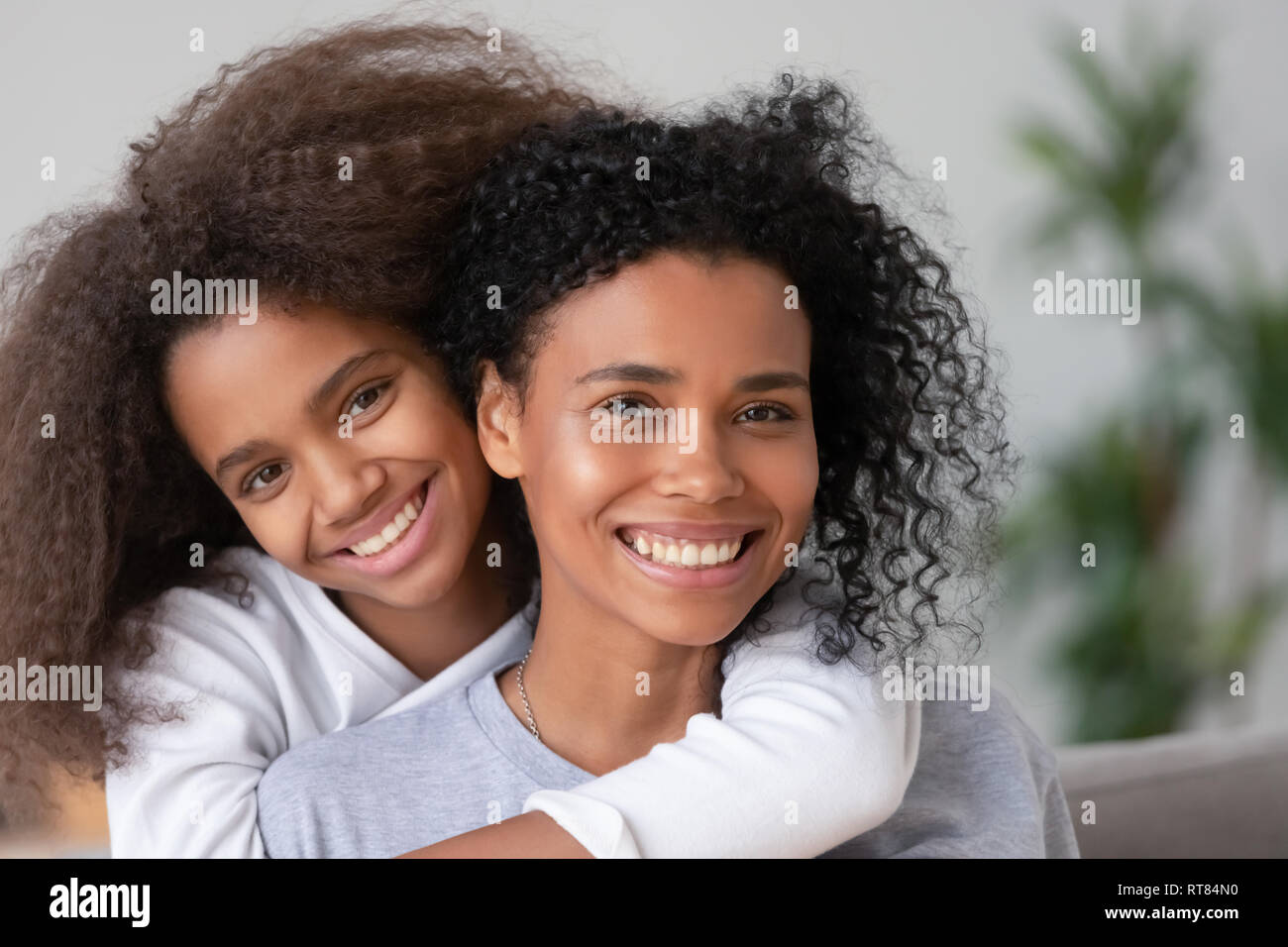 Heureux de l'Afrique mère et fille de câliner looking at camera Banque D'Images