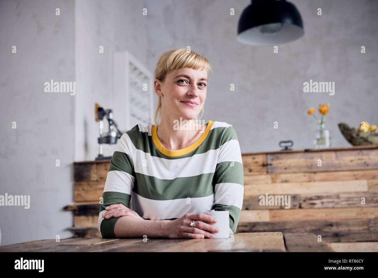 Portrairt de smiling woman with coffee mug at tablet Banque D'Images