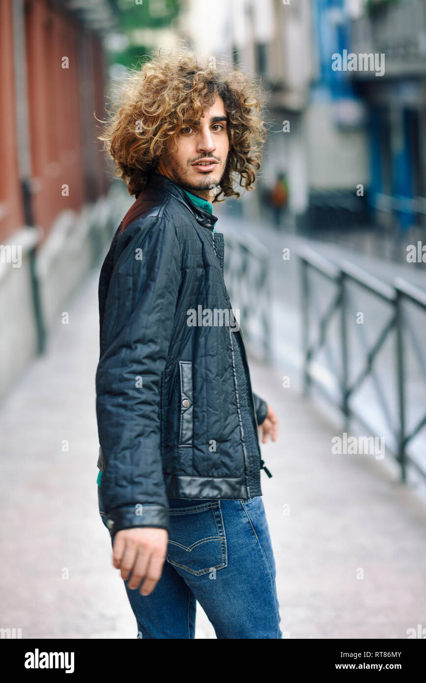 L'Espagne, Grenade, portrait de jeune homme avec les cheveux bouclés sur la chaussée de marche Banque D'Images