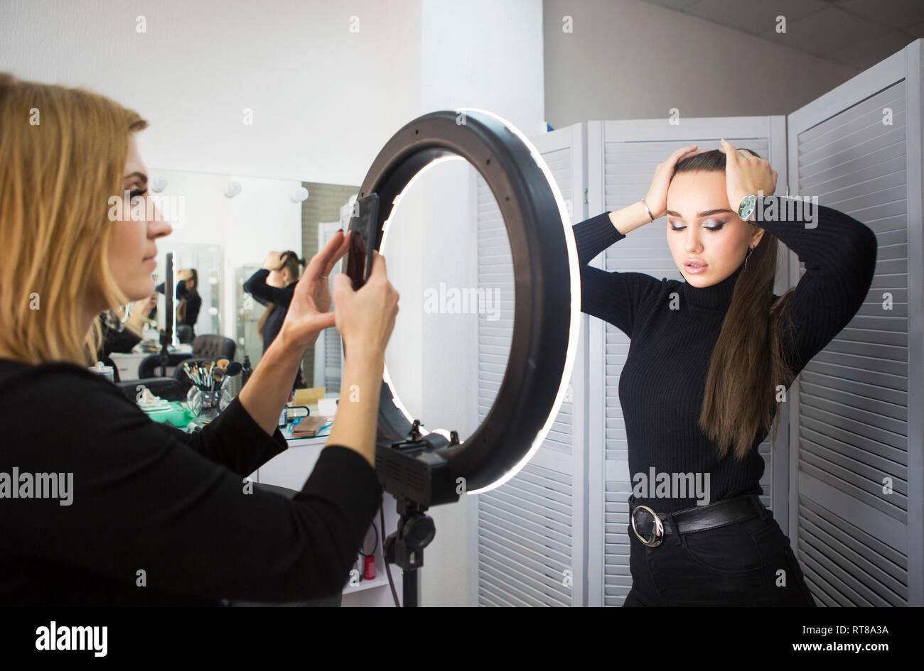 Faire prendre de l'artiste photo mobile pour le modèle avec un miroir Banque D'Images