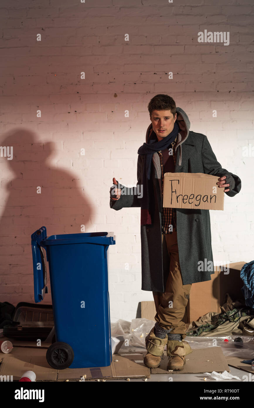 Homeless man showing ok sign et la tenue de la carte en carton avec l'inscription "freegan" Banque D'Images