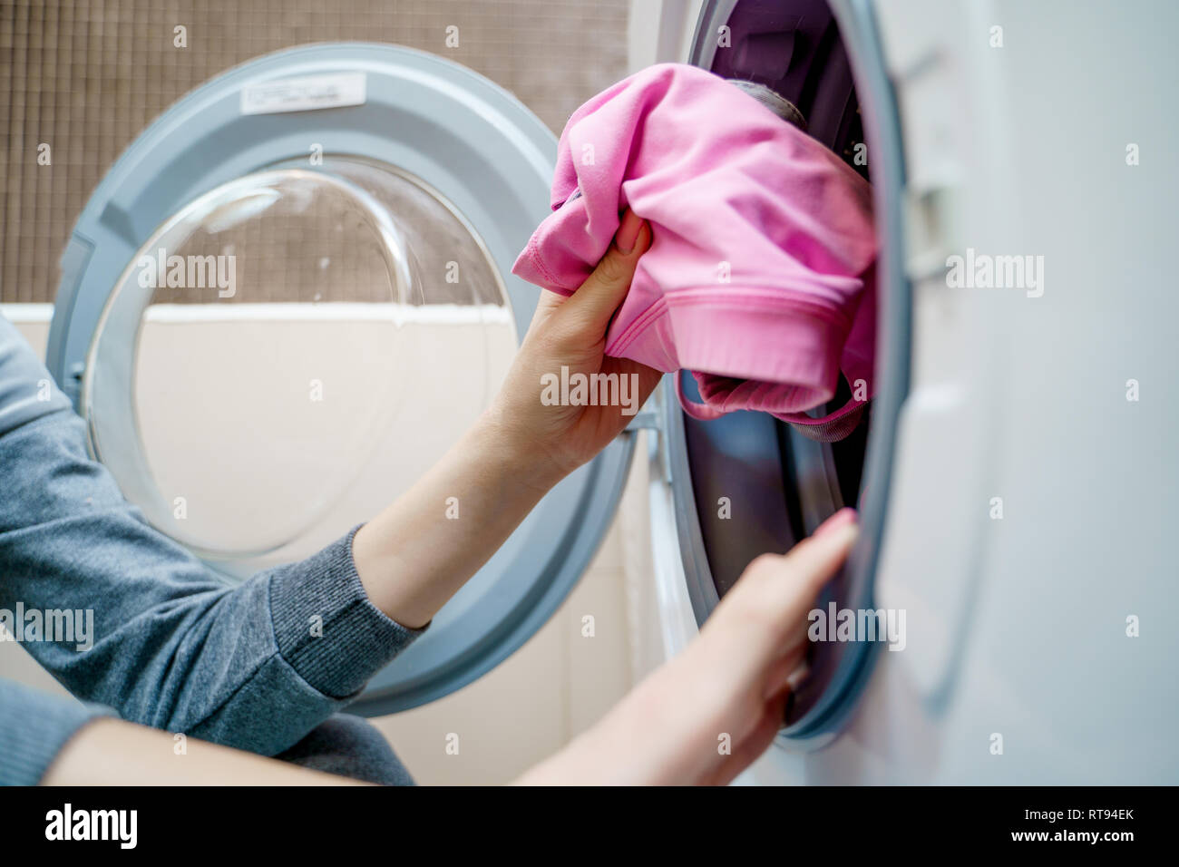 Women's Hands mettre la lessive dans un lave-linge Banque D'Images