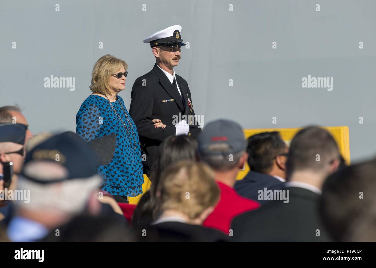 SAN DIEGO (janv. 26, 2019) Sally Monsoor, mère de Michael Monsoor et la marraine du navire, est accompagné sur scène lors de la cérémonie de mise en service pour les missiles de l'USS Michael Monsoor (DDG 1001). DDG 1001 est le deuxième destroyer de classe Zumwalt navire à entrer dans la flotte. Il est le premier navire de combat de la Marine nommé en l'honneur Master-at-Arms 2e classe (JOINT) Michael Monsoor, qui a reçu à titre posthume la Médaille d'honneur pour ses actions héroïques tout en servant à Ramadi, en Irak, en 2006. Banque D'Images