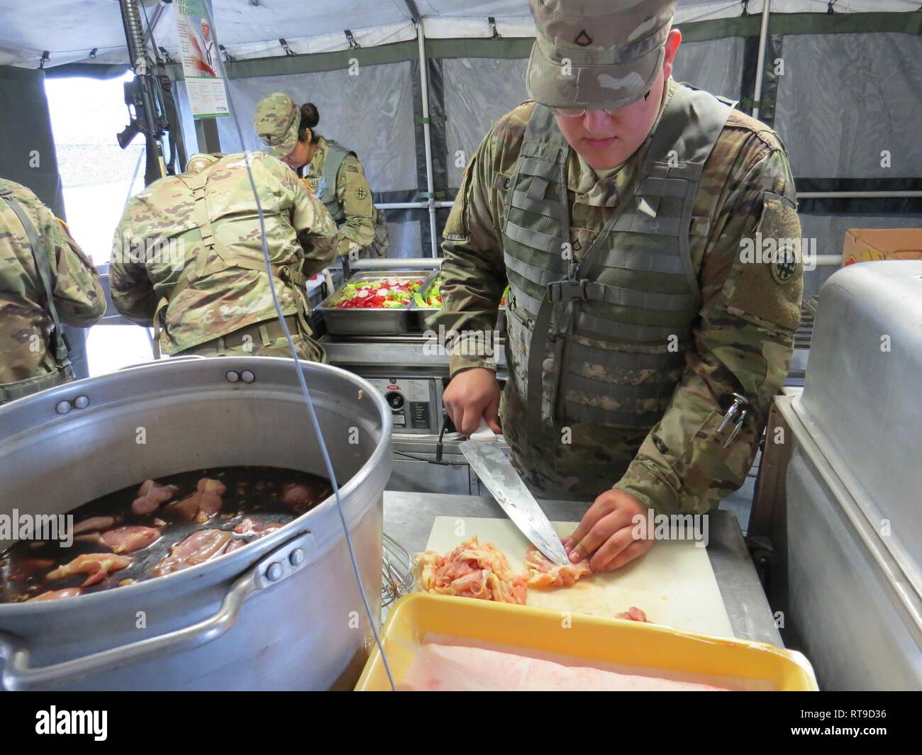 Réserve de l'armée américaine la FPC. Joe-Izaak - Pix-geeks.com, un spécialiste de la restauration avec la 370e compagnie de transport, 319e Bataillon de soutien de soutien au combat, 4e corps expéditionnaire (Commande de soutien), 79e Theatre le maintien en puissance, coupe commande poulet pour le plat principal au cours de la finale du concours Philip A. Connelly, le 26 janvier 2019, à Brownsville, Texas. - Pix-geeks.com a chanté tout en travaillant pour motiver son équipe comme ils ont préparé un menu choisi. Le Philip A. Connelly Programme est la personnification de l'excellence du service alimentaire exécutés par des spécialistes culinaires résultant en la présentation d'extrêmement satisfaire Banque D'Images