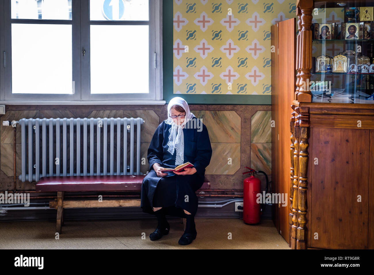 Lettonie : Riga. L'intérieur du style néo-classique, l'église Saint Alexandre Nevsky dans la Rue Brivibas, une femme portant un fichu sur sa tête une prière lecture boo Banque D'Images