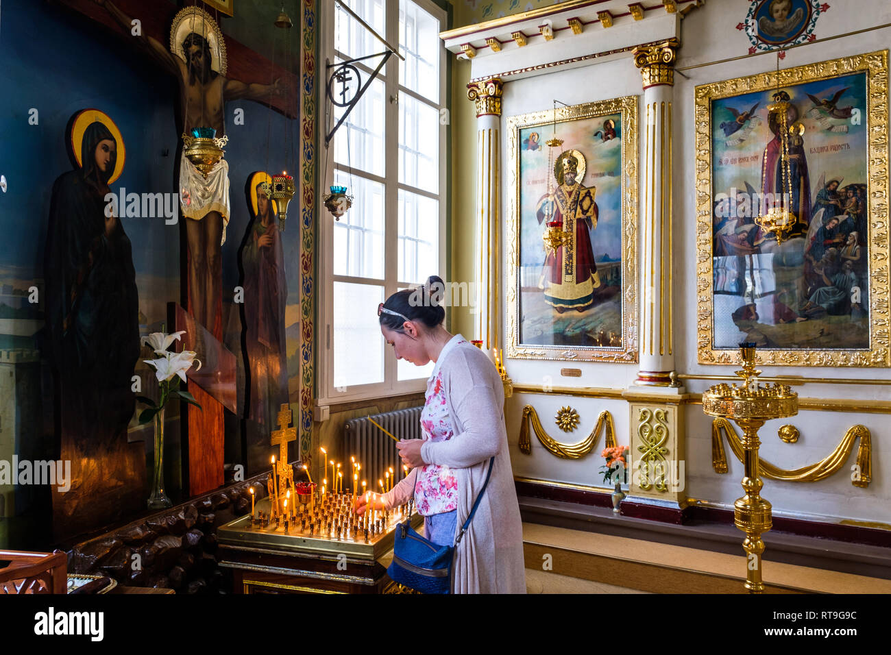 Lettonie : Riga. L'intérieur du style néo-classique, l'église Saint Alexandre Nevsky dans la Rue Brivibas, une femme allumant une bougie. La moitié de la population de Riga Banque D'Images