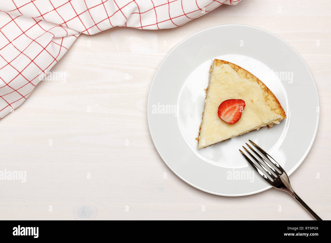 Une tranche de gâteau au fromage aux fraises sur une plaque blanche. Vue d'en haut. Copy space Banque D'Images