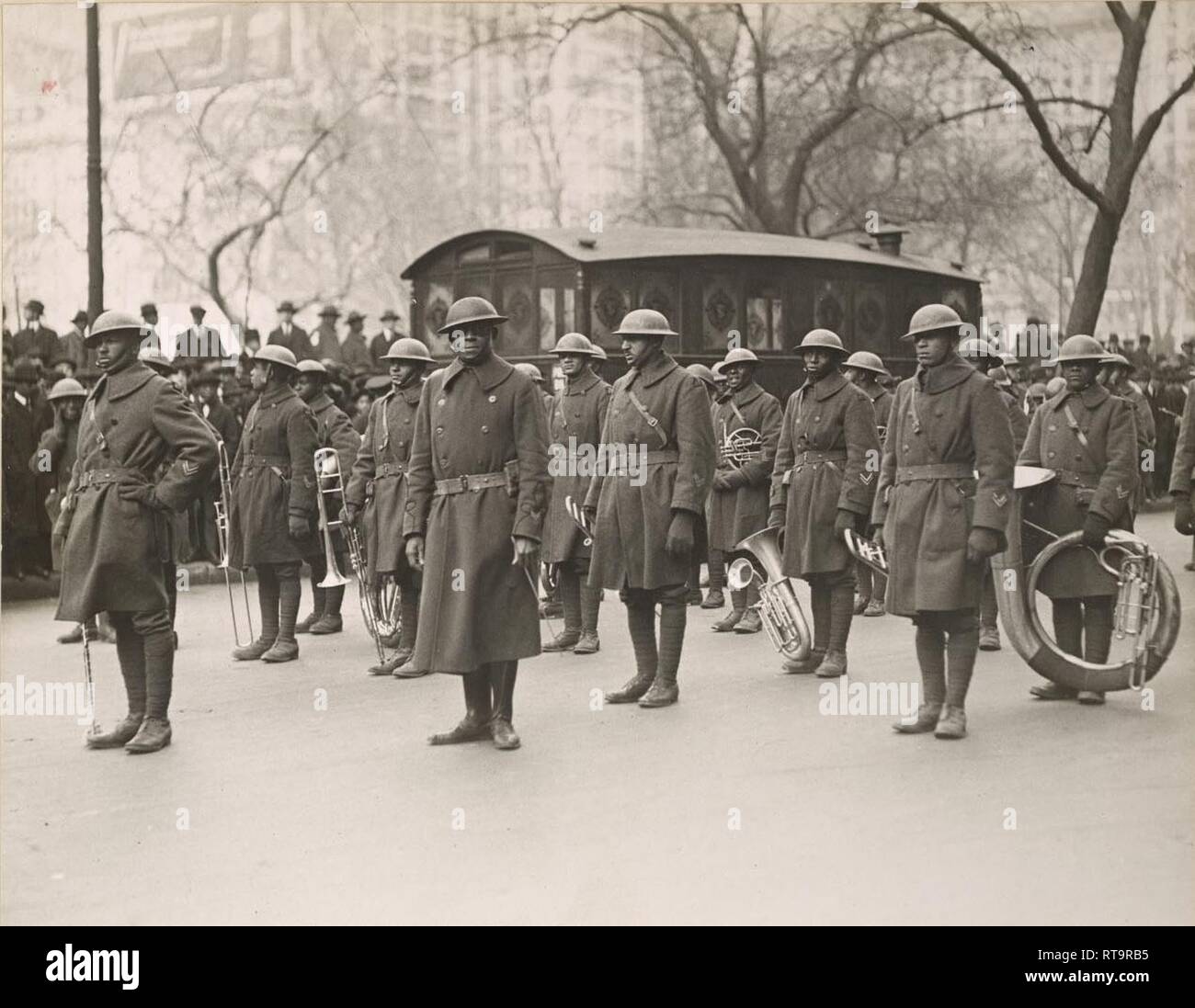 Les soldats de la 369e Régiment d'infanterie band stand au repos pendant qu'ils attendent à mars de la Cinquième Avenue à New York City le 17 février 1919 lors d'un défilé tenu à saluer la Garde Nationale de New York accueil. Plus de 2 000 soldats ont pris part au défilé de la Cinquième Avenue. Les soldats ont marché 11 kilomètres du centre-ville de Manhattan à Harlem. Le groupe était dirigé par le Lieutenant James Reese musicien noté ' Jimmie" l'Europe, vu au centre portant des lunettes. ( Archives nationales) Banque D'Images