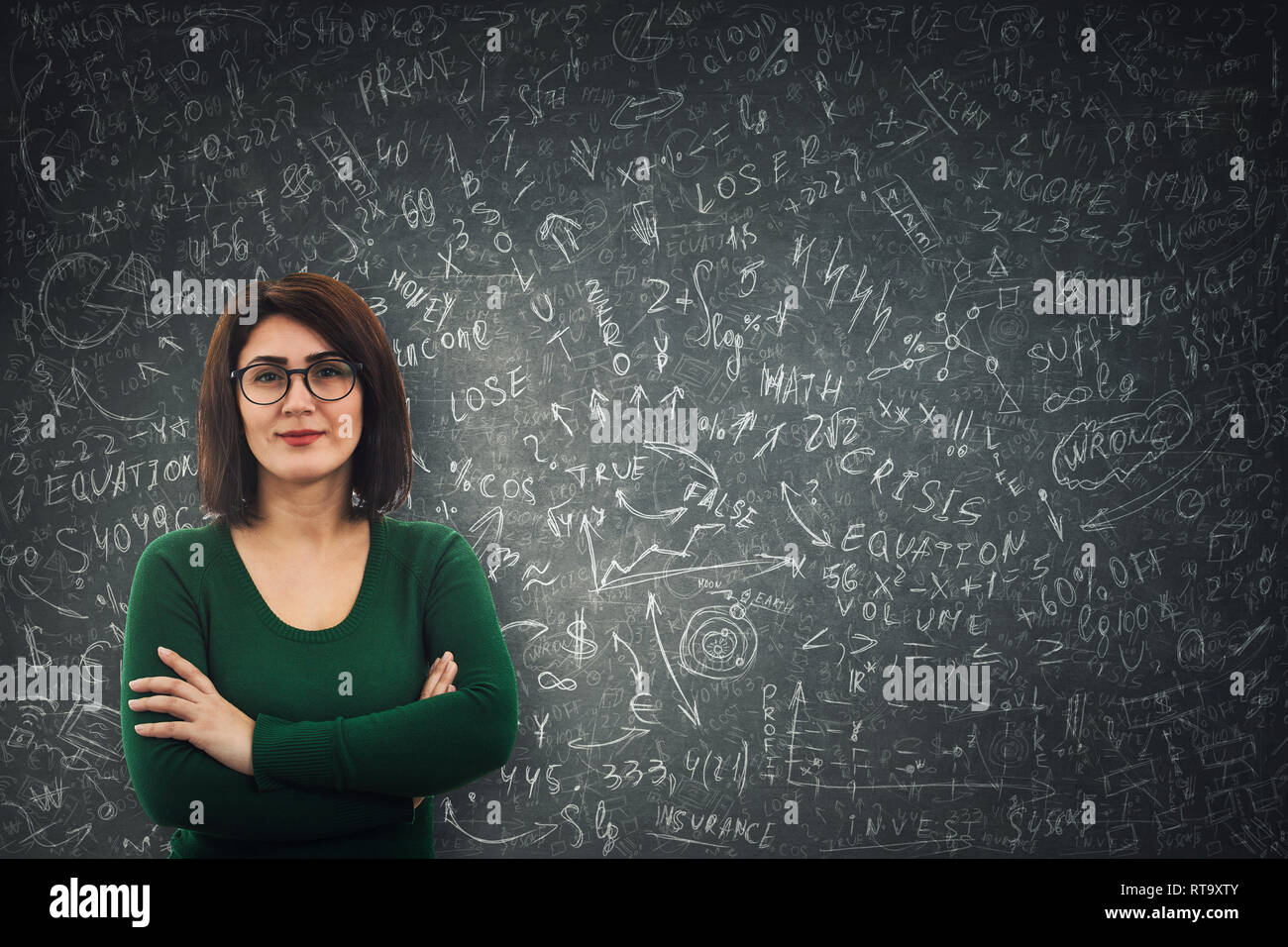 Confident businesswoman wearing glasses, debout devant un tableau noir de problèmes mathématiques difficiles, l'économie et la formule de calcul des équations. Penser Banque D'Images