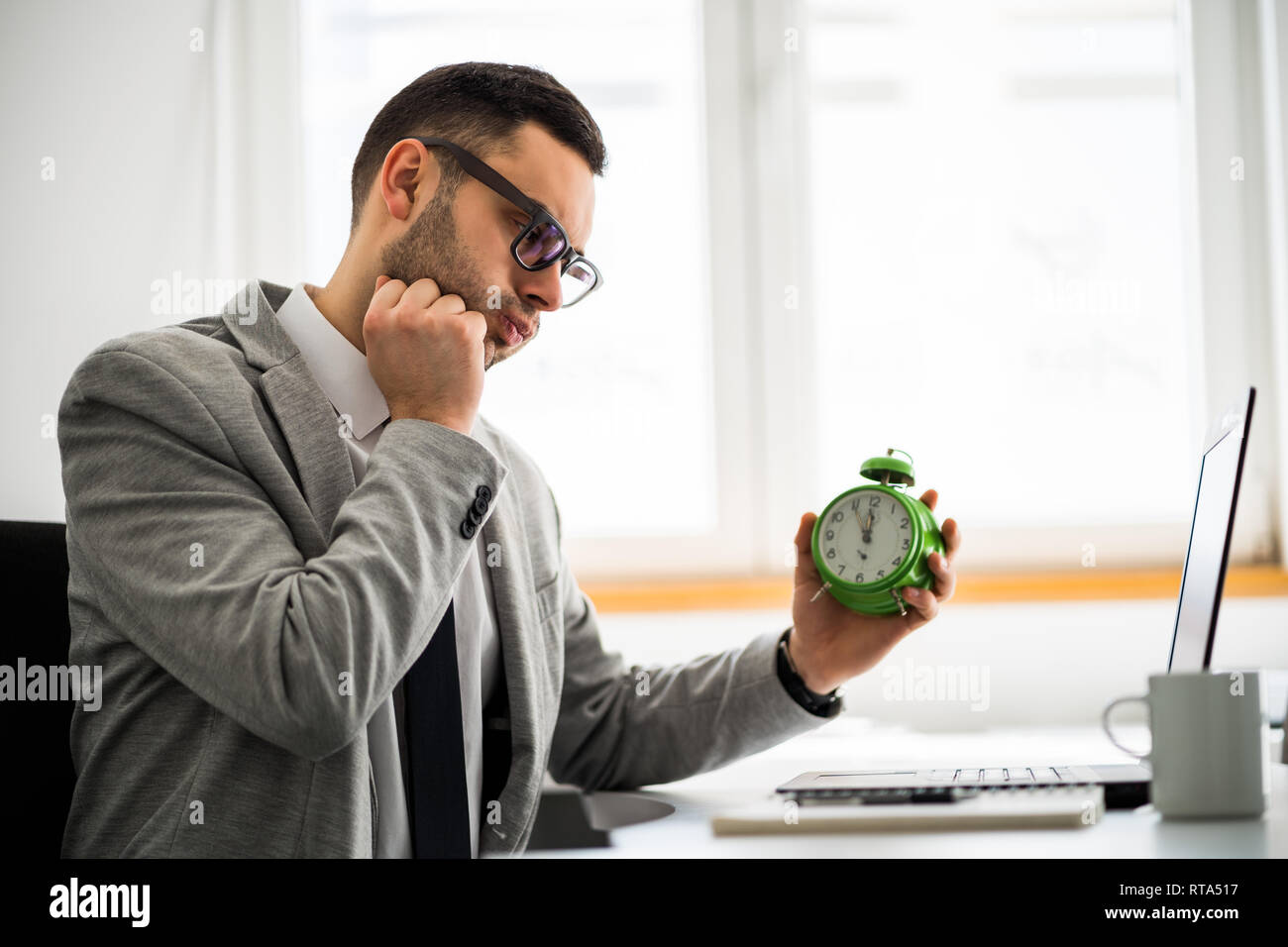 Jeune homme travaille dans le bureau. Il est en retard sur l'horaire. Banque D'Images