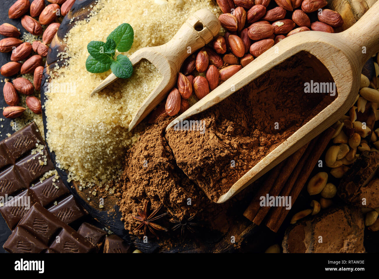 Poudre de cacao, chocolat, noix et d'épices sur une table en bois. La photographie alimentaire Banque D'Images