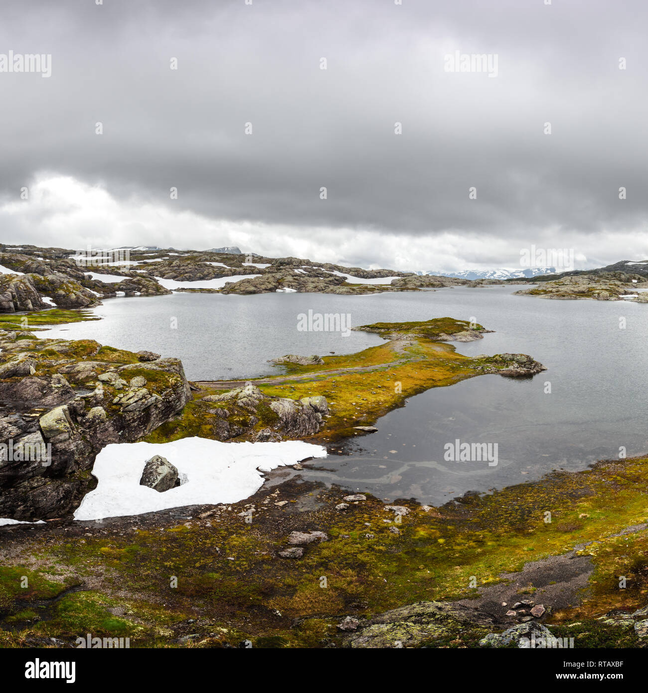 Paysage norvégien typique avec les montagnes enneigées et le lac clair près du Trolltunga rock - plus spectaculaire et célèbre falaise pittoresque en Norvège Banque D'Images