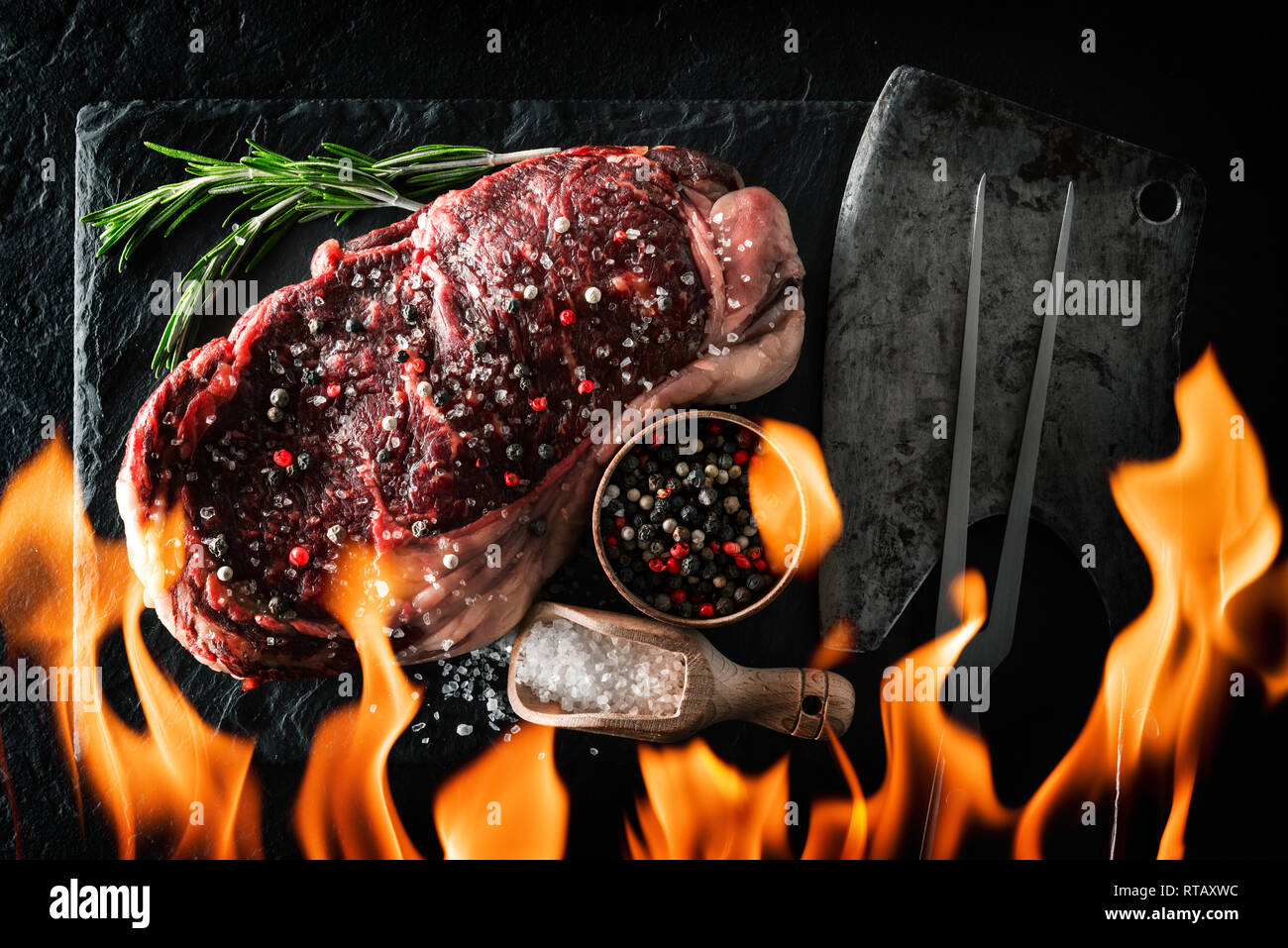 Le persillage Ribeye Steak sur plaque noire avec effet de flamme. Hacher la viande de boeuf Banque D'Images