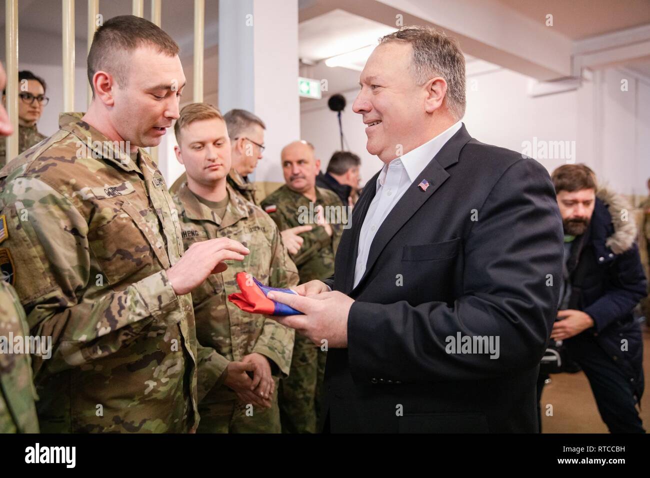 Le sergent de l'armée américaine. Kristopher Gore, un Texas Army National Guard fantassins attribué à Battle Group Pologne, présente la secrétaire d'État des États-Unis, Michael R. Pompeo avec un drapeau de l'État du Tennessee signé par les soldats de la Force Raider's Avenger Troop, 3e peloton, à Bemowo Piskie Domaine de formation, Pologne, le 13 février. La Pologne est un groupe de combat de la coalition multinationale unique des États-Unis, Royaume-Uni, croate et soldats roumains qui servent dans le cadre de la 15e Brigade mécanisée polonaise comme une force de dissuasion de l'OTAN à l'appui de l'OTAN vers l'amélioration de présence (PEF). Banque D'Images