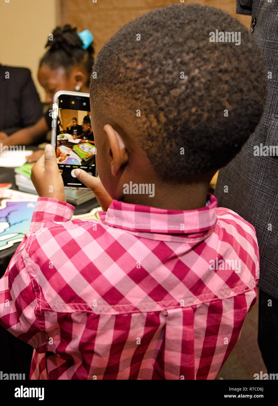 Un garçon prend une photo de sa sœur, Nia Mya Reese, alors qu'elle signe des exemplaires de son livre intitulé, "la manière de traiter et prendre soin de votre petit frère ennuyeux." Banque D'Images