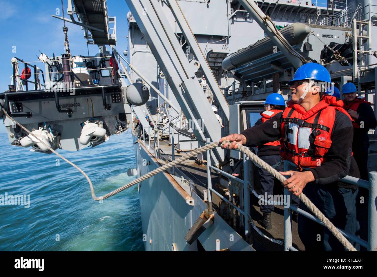 Océan Pacifique (fév. 15, 2019) Jonathan Marin Castillo, de Garfield, New Jersey, heaves line comme marins un inférieur à coque rigide à bord de la classe de Harpers Ferry landing ship dock amphibie USS Harpers Ferry (LSD 49) pendant les opérations de bateau. Harpers Ferry est en cours, la réalisation des opérations de routine dans le cadre d'un groupe amphibie USS Boxer (ARG) dans l'océan Pacifique. Banque D'Images