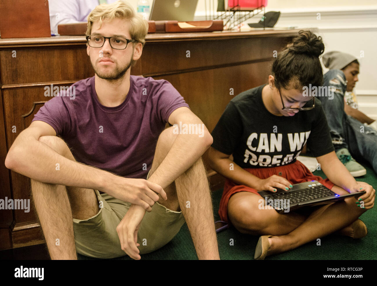 Giovanni Rocco, 21 ans, à l'écoute au cours d'un rêve humains réunion tandis que Isis Alvarez, 19, surveille les médias sociaux à Tallahassee, Floride. Banque D'Images