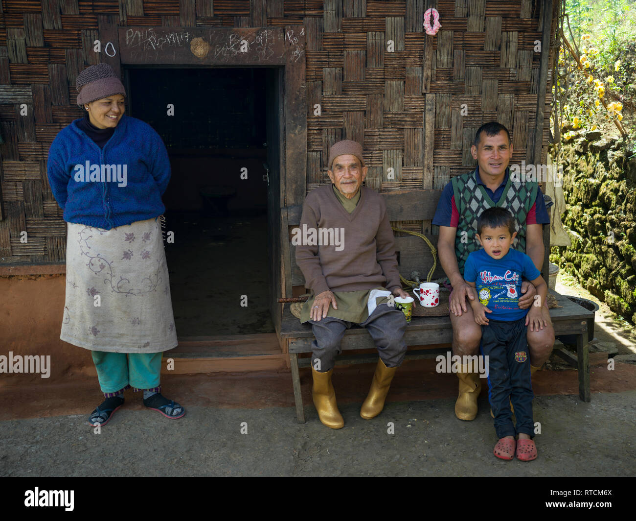 Famille assis sur le perron de la maison, le Sikkim, Inde Banque D'Images