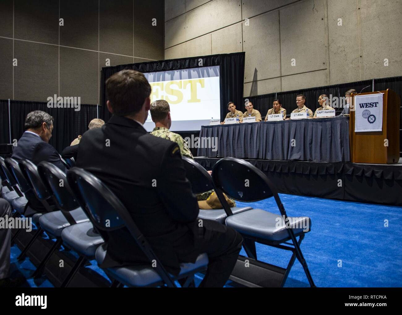 SAN DIEGO (fév. 14, 2019) Le lieutenant Cmdr. Sophia Haberman, le centre de la scène, une surface / de guerre anti-sous-marine (ASM/SUW) Instructeur de tactiques de guerre (WTI), affectés à la surface de la Marine et de la guerre des mines (Centre de développement de l'SMWDC), réponses aux questions de l'auditoire pendant une SMWDC au bord du WTI WEST 2019 au San Diego Convention Center, le 14 février. Marine Le SMWDC établi comme l'un des cinq WDCs en 2015 afin d'harmoniser et de synchroniser les efforts de guerre de la flotte à la surface, l'air, sous-marine, de l'information, et expéditionnaires domaines. Cette année, le thème de l'ouest de trois jours de l'événement 2019 était "l'aiguisage Banque D'Images