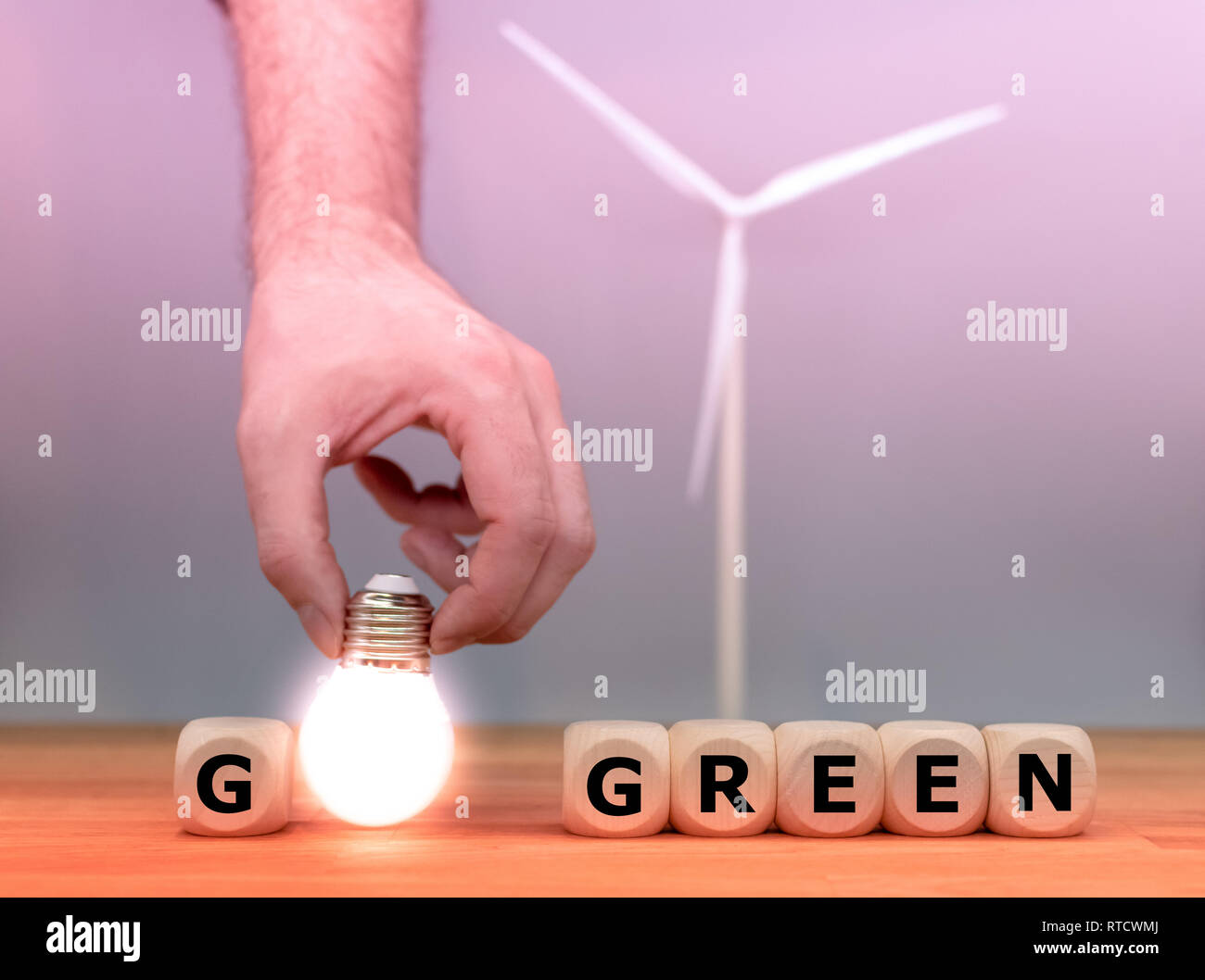 Dés et une ampoule pour former les mots "passer au vert" en face d'un modèle d'éolienne. Banque D'Images