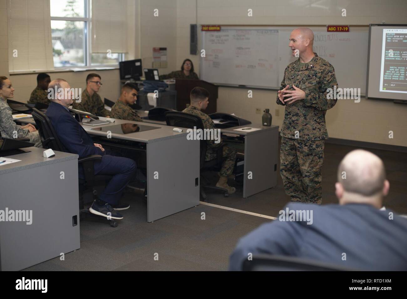 Le Lieutenant-colonel du Corps des Marines américain Casey L. Taylor, commandant de l'Administration du personnel de l'école, Marine Corps Combat Service Support les écoles (MCCSSS), procède à un bref pour l'US Air Force et du système de rémunération du personnel intégré au Camp d'équipe Johnson, N.C., le 19 février, 2019. Dr Michael A. Parker, directeur de l'information et de directeur adjoint, Plans et de l'intégration, l'Administration centrale de l'aviation américaine, a visité l'MCCSSS pour mieux comprendre comment la Force Totale du Corps des Marines et le fonctionnement du système de formation qu'elle englobe. Banque D'Images