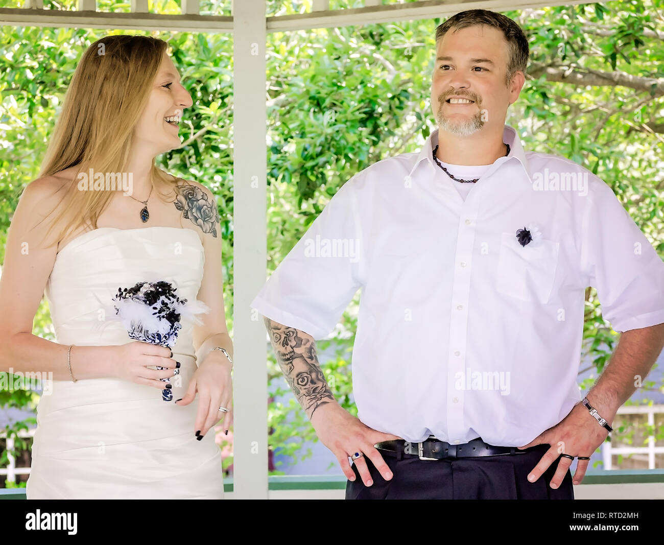 Les nouveaux mariés rire comme ils parlent après leur cérémonie de mariage au parc Marshall à Ocean Springs, Mississippi. Banque D'Images