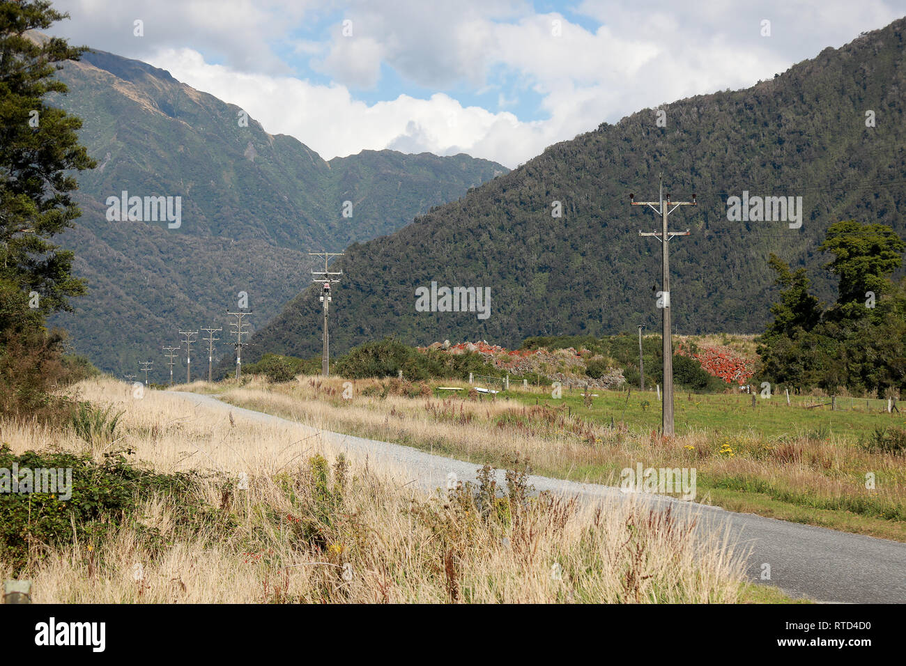 Pays de gravier dans les montagnes avec pylônes et fils électriques près de Franz Josef Nouvelle-zélande Île du Sud, côte ouest Banque D'Images