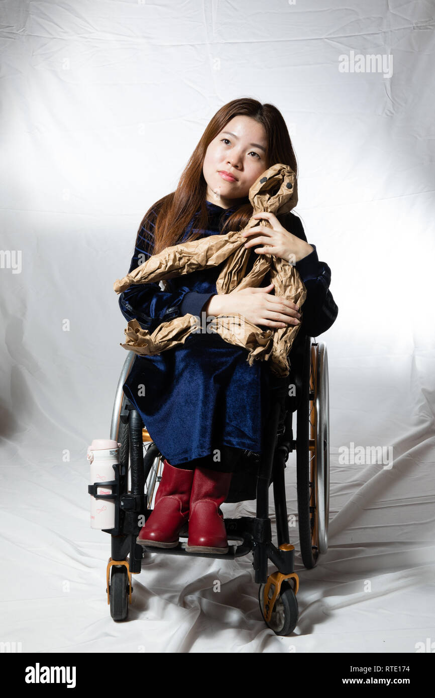 (190301) -- BEIJING, 1 mars 2019 (Xinhua) -- Cheng Liting, 28 ans, un diagnostic de paralysie infantile, pose pour un portrait à Beijing, capitale de la Chine, 26 février 2019. Cheng s'est inscrit à un cours de formation en conception de jeu en 2011, mais avait du mal à monter les escaliers vers la salle de classe qui était au deuxième étage. Chaque jour de ce mois, elle avait d'arriver tôt et d'attendre par l'escalier à demander l'aide d'autres étudiants. Personne n'a rejeté et il lui a donné le courage de demander de l'aide. Rare "Hug", un drame chinois sur les maladies rares, a été organisé à Beijing Tianqiao Performing Arts Centre Le mercredi soir Banque D'Images